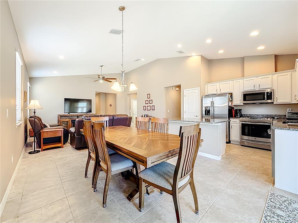 5647 Northwest 37th Lane Road Ocala, FL 34482 - Photo 8 of 50 a kitchen with stainless steel appliances kitchen island granite countertop a table chairs and a refrigerator