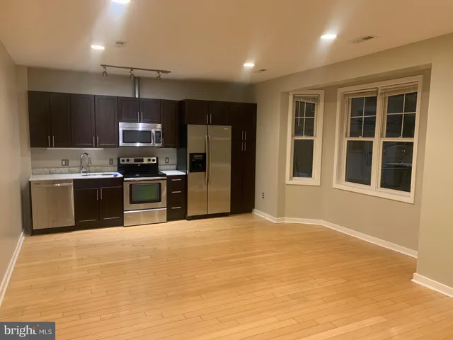 a large kitchen with stainless steel appliances granite countertop a stove and a sink
