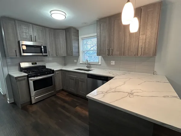 a kitchen with granite countertop a sink stainless steel appliances and cabinets
