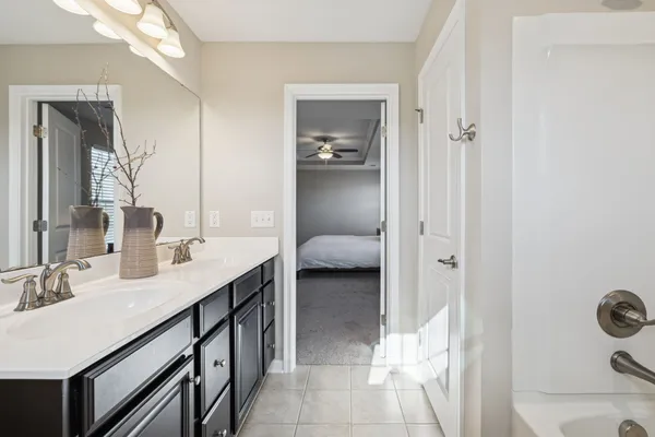 a en suite bathroom with a granite countertop sink and a mirror