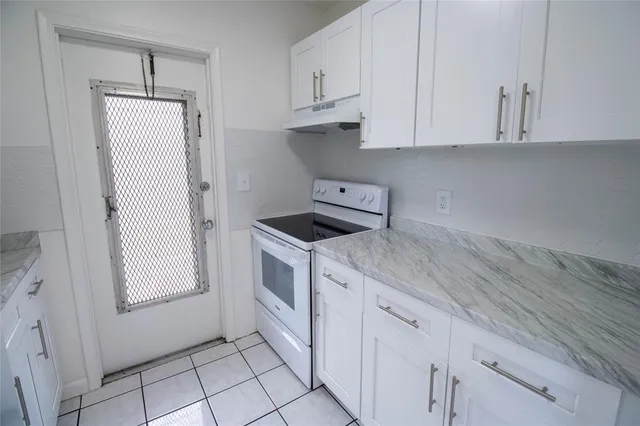 a kitchen with white cabinets and white appliances