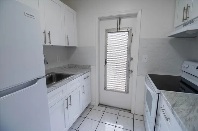 a kitchen with white cabinets and white appliances