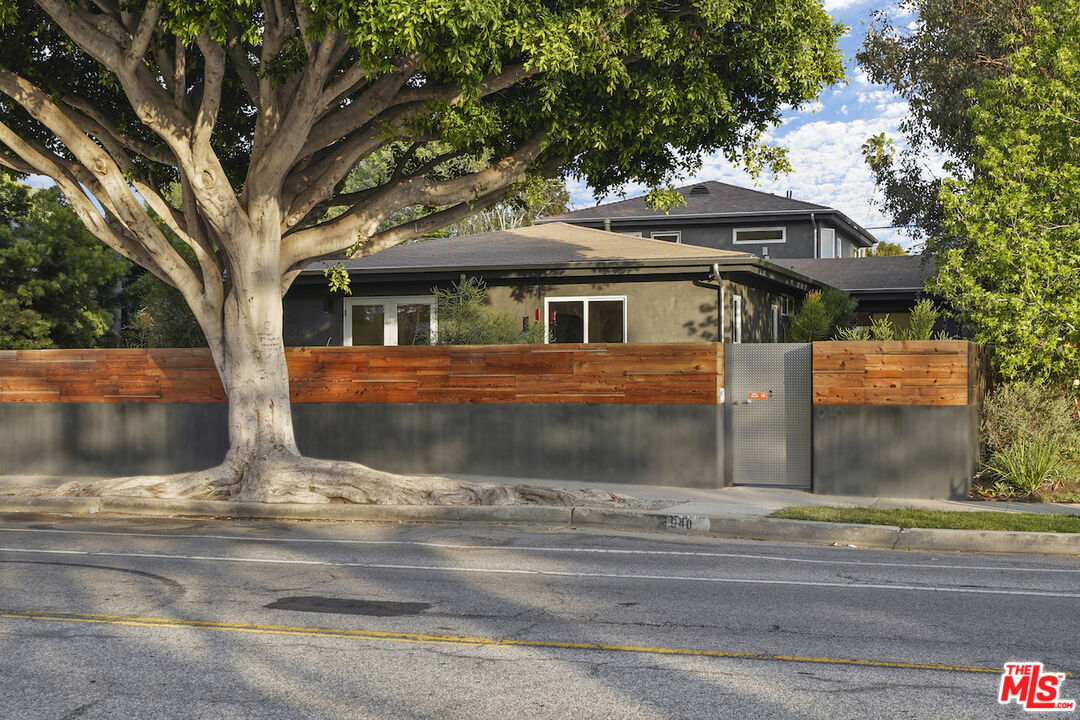 940 Rose Avenue Venice, CA 90291 - Photo 37 of 39 a view of a white house with large tree and wooden fence