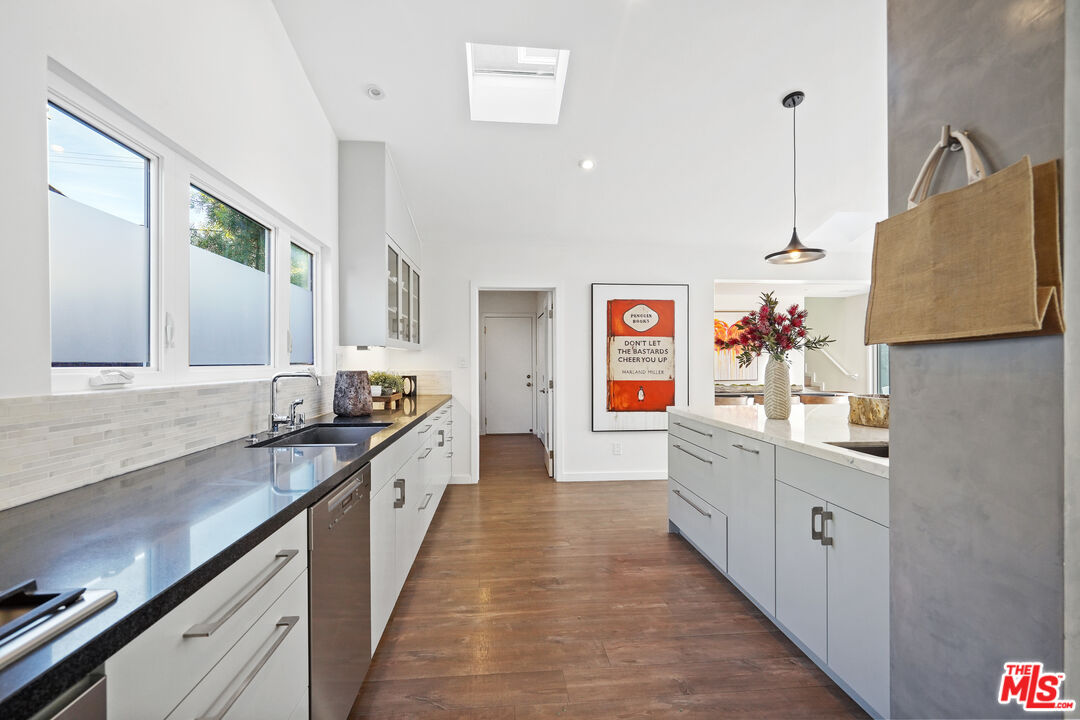 940 Rose Avenue Venice, CA 90291 - Photo 8 of 39 a large kitchen with stainless steel appliances granite countertop a sink and dishwasher a refrigerator with wooden floor