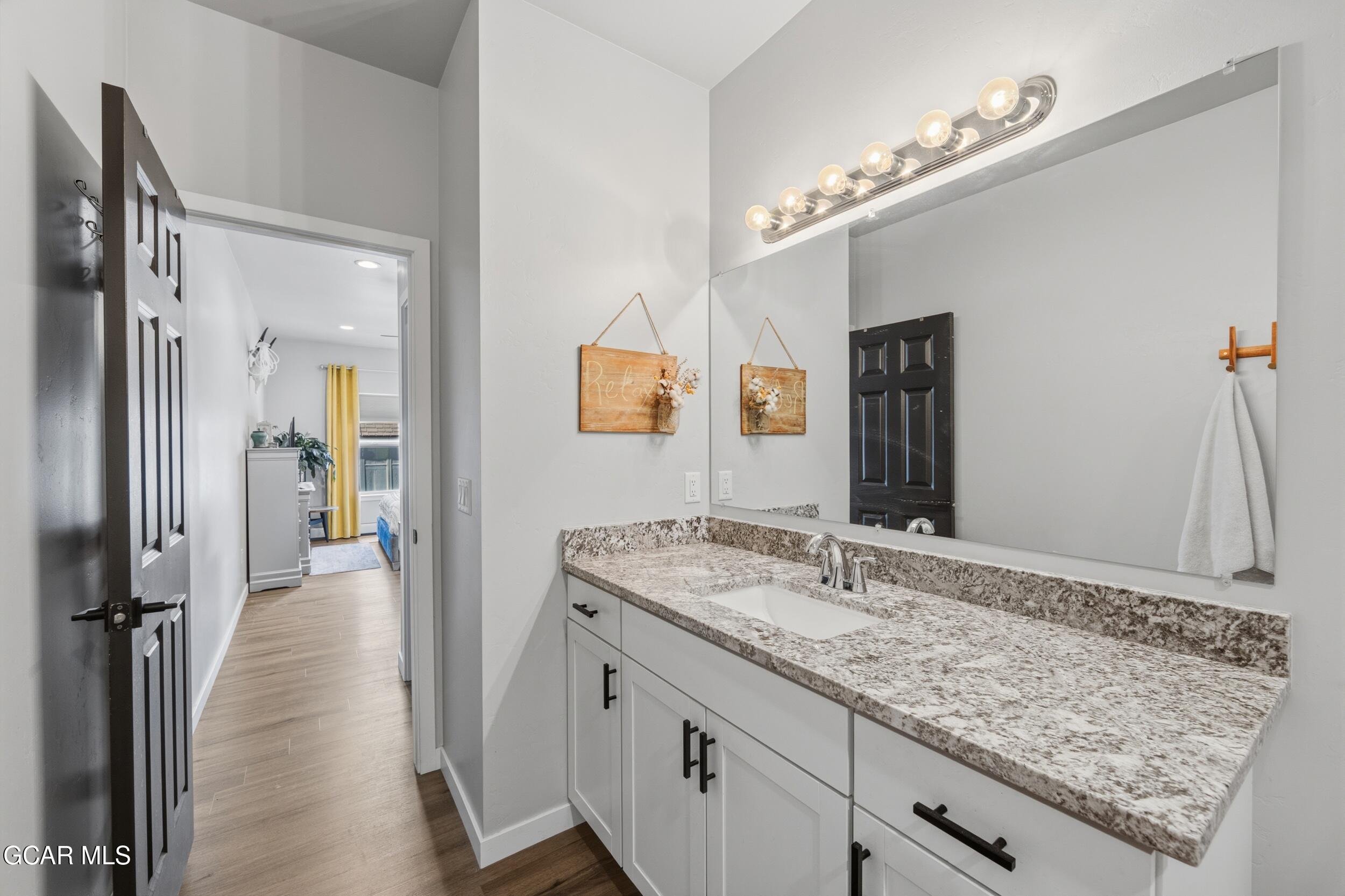 503 12th Street, Unit B Kremmling, CO 80459 - Photo 19 of 44 a bathroom with a granite countertop sink and a mirror