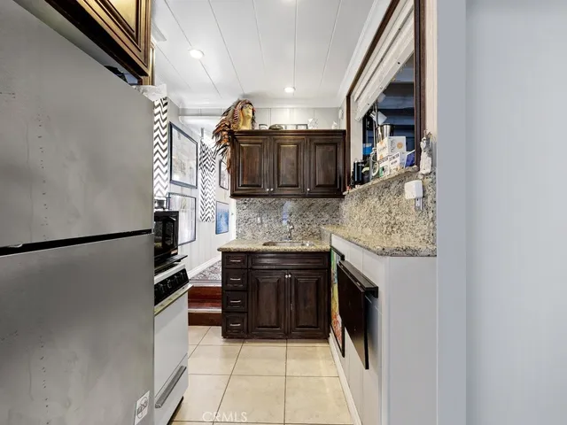 a kitchen with stainless steel appliances granite countertop a refrigerator and a sink