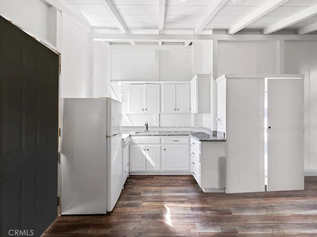 a kitchen with white cabinets and refrigerator