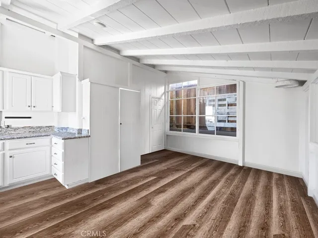 a view of empty room with wooden floor and cabinet