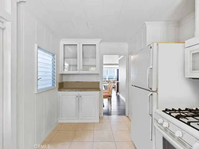 a kitchen with a refrigerator a stove and white cabinets