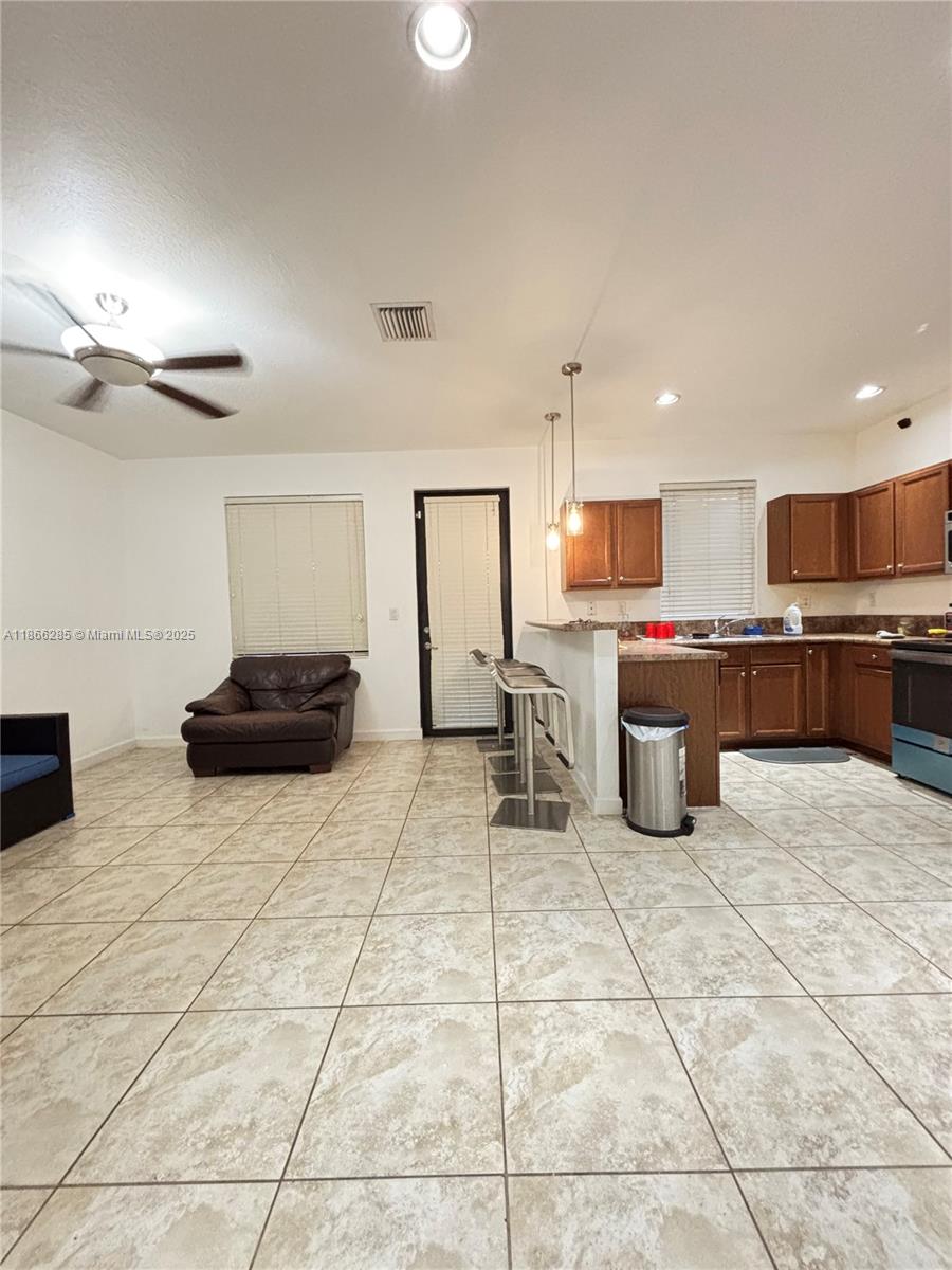 17443 Southwest 153rd Path, Unit 17443 Miami, FL 33187 - Photo 3 of 10 a kitchen with stainless steel appliances a sink a stove a microwave a counter top space and cabinets