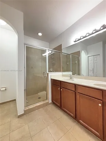 a bathroom with a shower a sink and a mirror