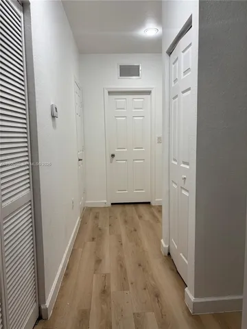 a view of a hallway with wooden floor