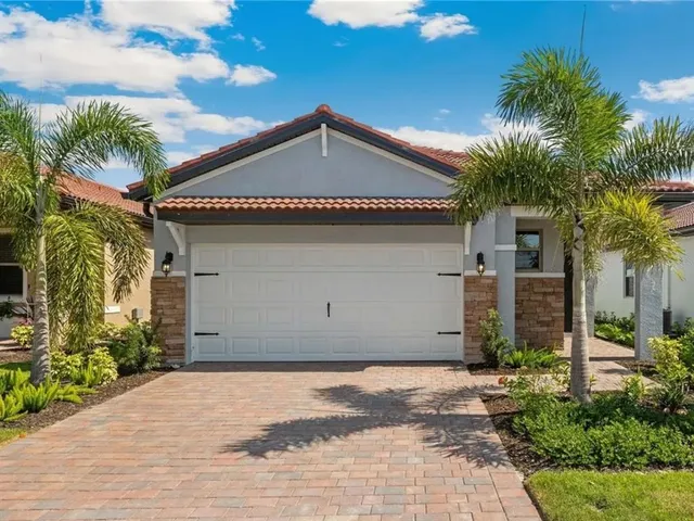 a view of a house with a yard and potted plants