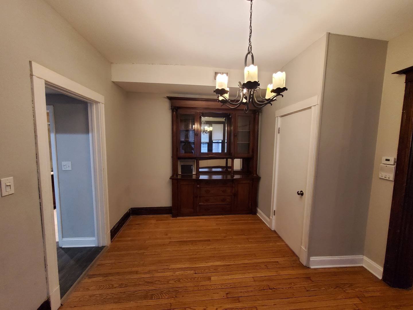 665 West Roscoe Street, Unit 1 Chicago, IL 60657 - Photo 5 of 10 a view of a hallway with wooden floor and a chandelier