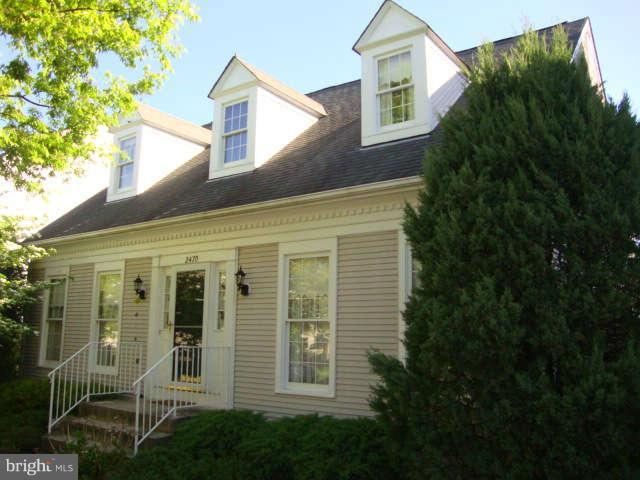 a view of a white house next to a yard
