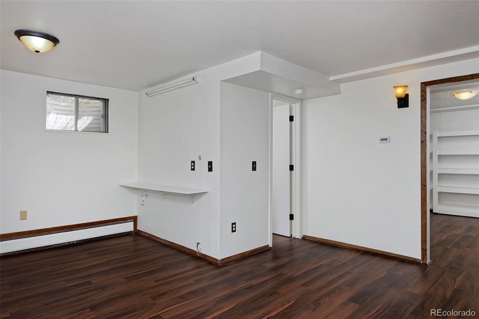 1340 Deerpath Trail Franktown, CO 80116 - Photo 29 of 44 a view of an empty room with wooden floor