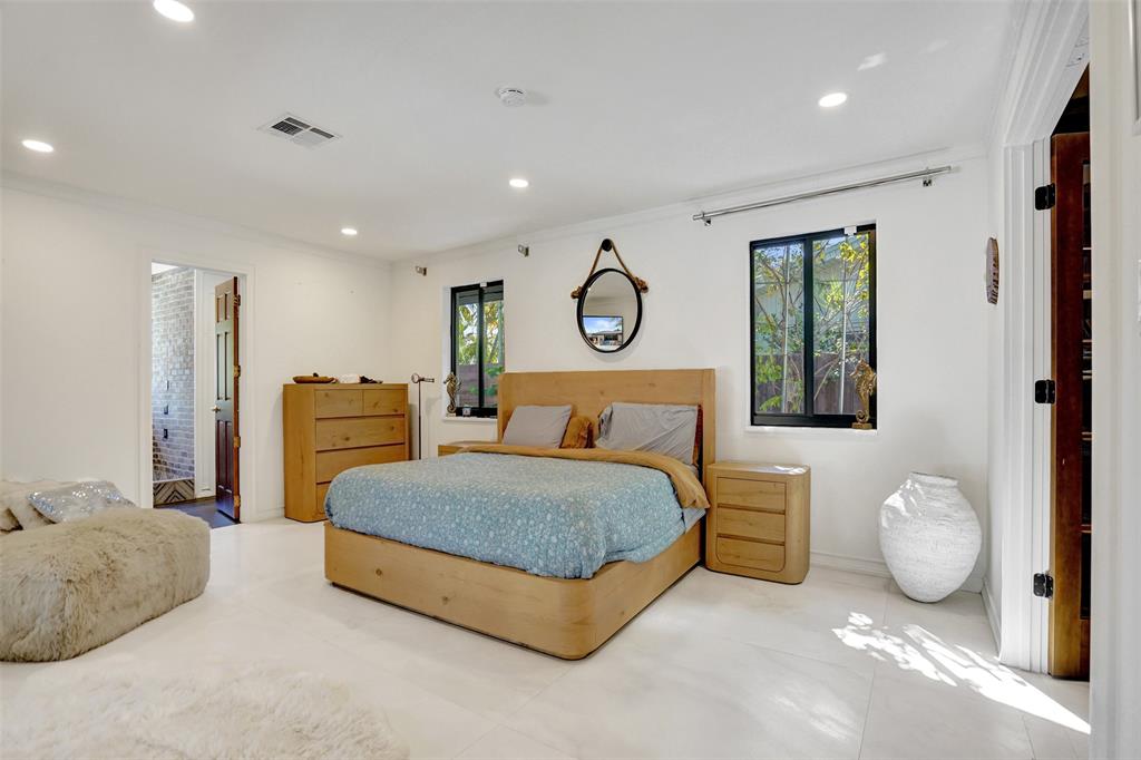 313 Layne Boulevard Hallandale Beach, FL 33009 - Photo 30 of 48 a spacious bedroom with a bed and painting on the wall