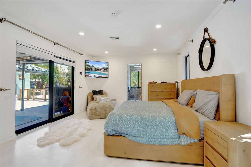 313 Layne Boulevard Hallandale Beach, FL 33009 - Photo 31 of 48 a bedroom with a large bed and sliding window