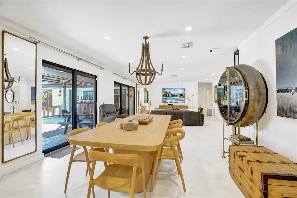 313 Layne Boulevard Hallandale Beach, FL 33009 - Photo 8 of 48 a view of a dining room with furniture wooden floor and a chandelier