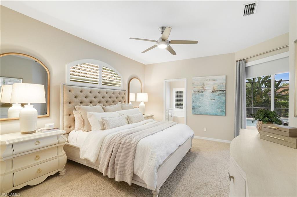 17897 Modena Road Miromar Lakes, FL 33913 - Photo 12 of 40 a bedroom with a large bed and a chandelier fan