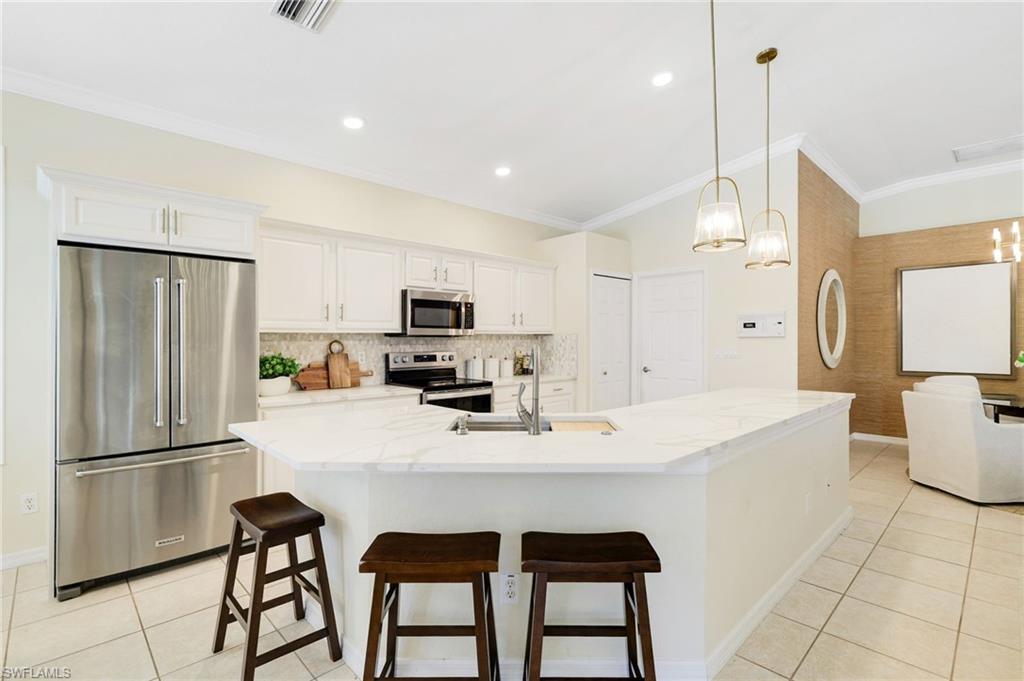 17897 Modena Road Miromar Lakes, FL 33913 - Photo 7 of 40 a kitchen with stainless steel appliances a refrigerator sink and stove