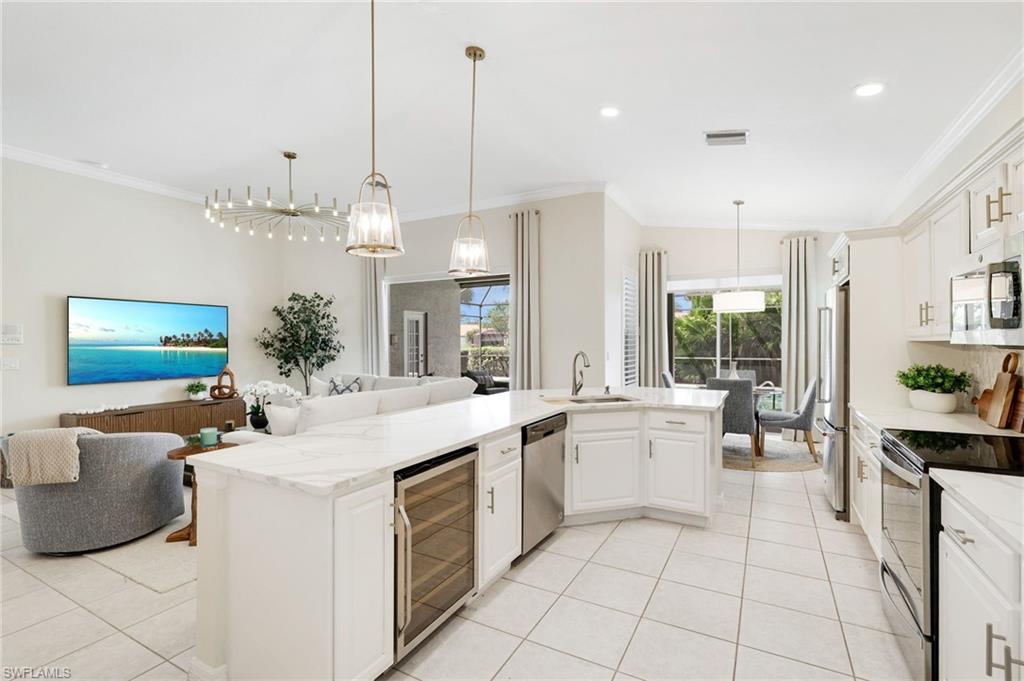 17897 Modena Road Miromar Lakes, FL 33913 - Photo 9 of 40 a large white kitchen with a large window and stainless steel appliances