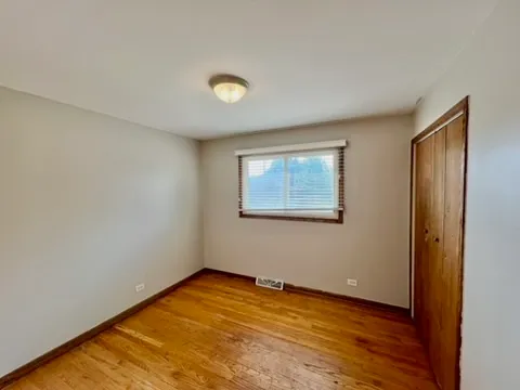 an empty room with wooden floor and window