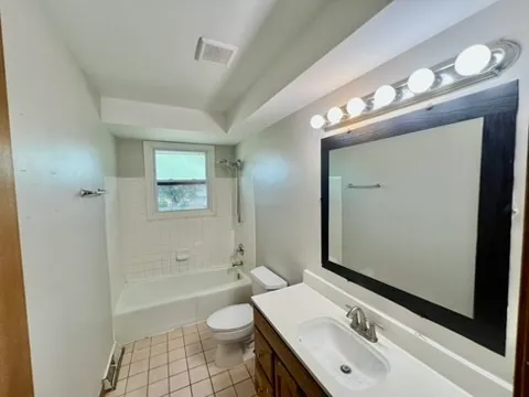 a bathroom with a sink a toilet a mirror and shower