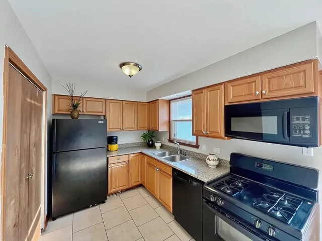 a kitchen with stainless steel appliances granite countertop a refrigerator stove top oven and sink