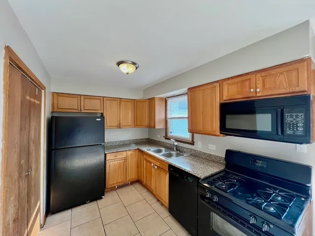 a kitchen with stainless steel appliances granite countertop a refrigerator stove and sink