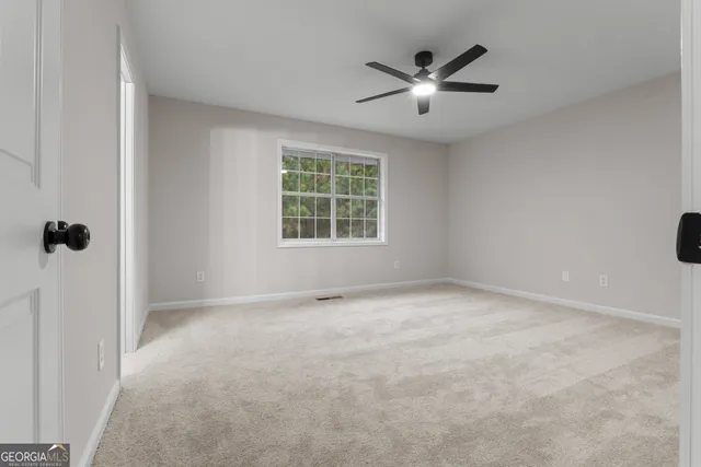 a view of empty room with ceiling fan