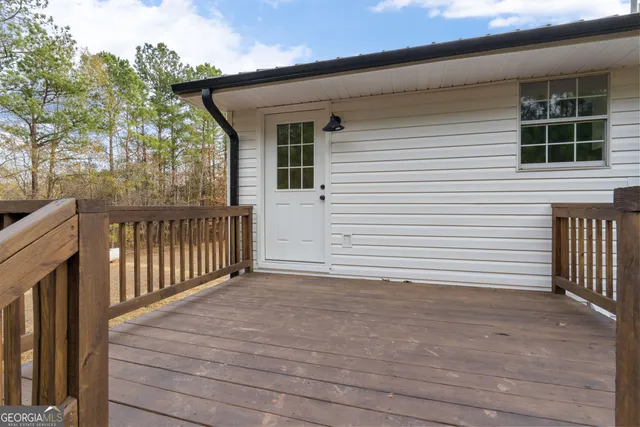 a backyard of a house with large trees and covered with wooden fence