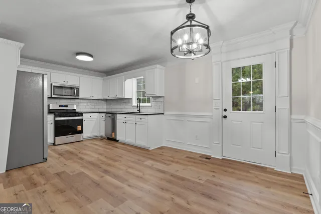 a open kitchen with stainless steel appliances granite countertop a refrigerator stove top oven and cabinets