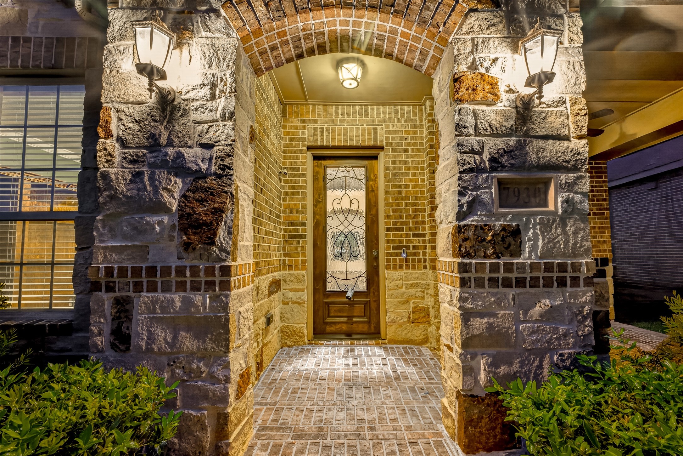 7930 Summer Night Lane Rosenberg, TX 77469 - Photo 42 of 48 Inviting covered front entry featuring elegant stone accents, an arched entryway, and a decorative glass front door.