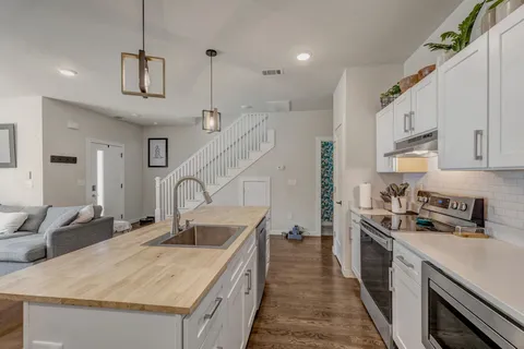 a kitchen with granite countertop a sink a counter top space stainless steel appliances and cabinets