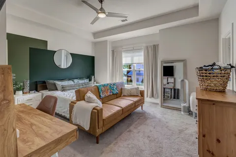 a spacious bedroom with a bed and dresser