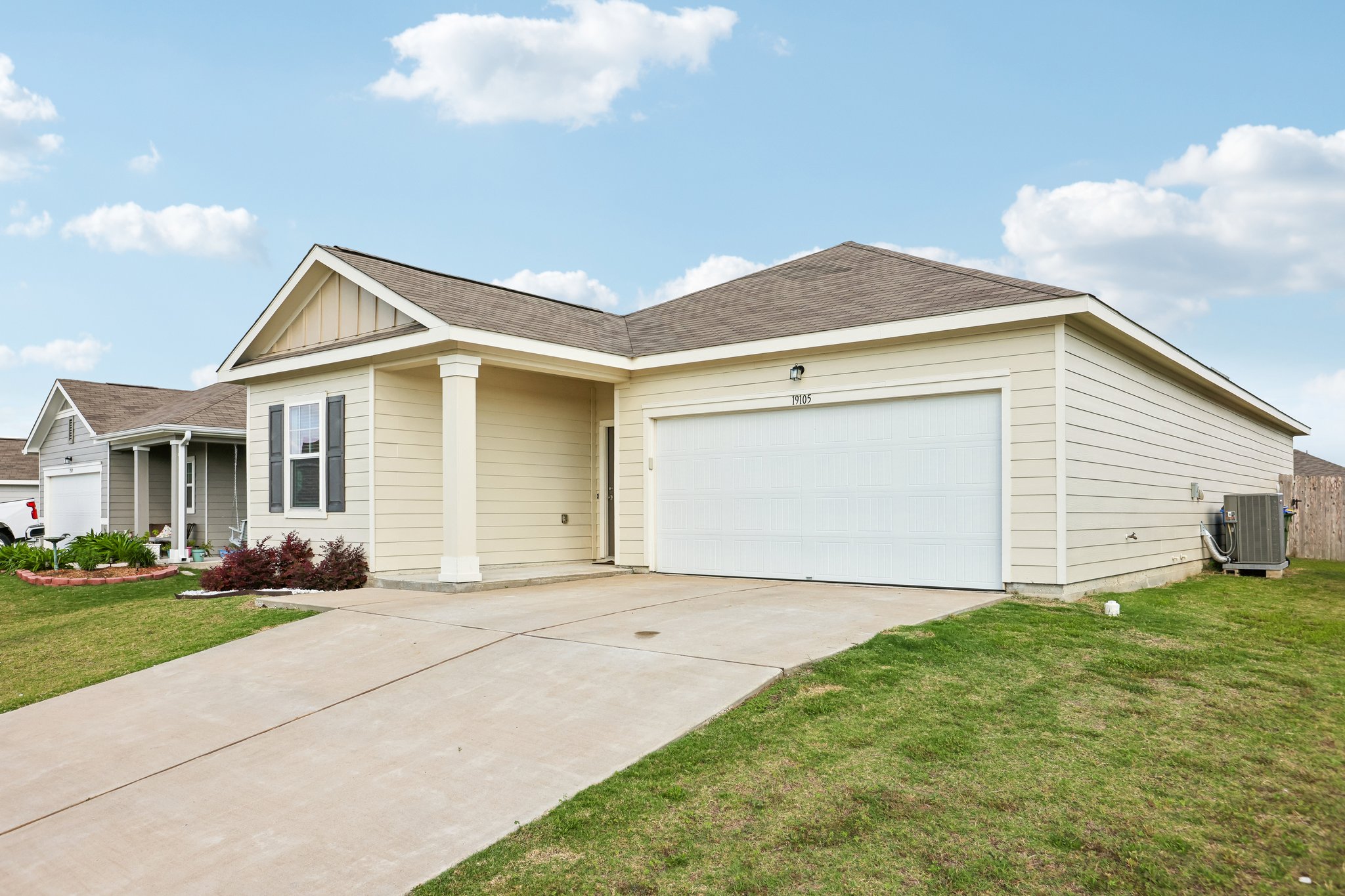 19105 Mike Mansfield Road Manor, TX 78653 - Photo 2 of 28 A welcoming front exterior with an attached garage and a neatly maintained lawn