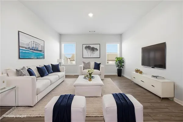 a living room with furniture two large mirror and a flat screen tv