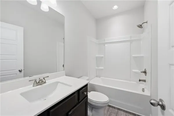 a bathroom with a sink toilet vanity and bathtub