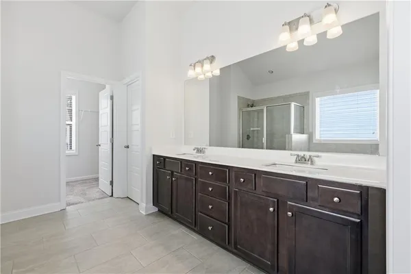 a bathroom with double vanity sinks a vanity a lamp and a mirror