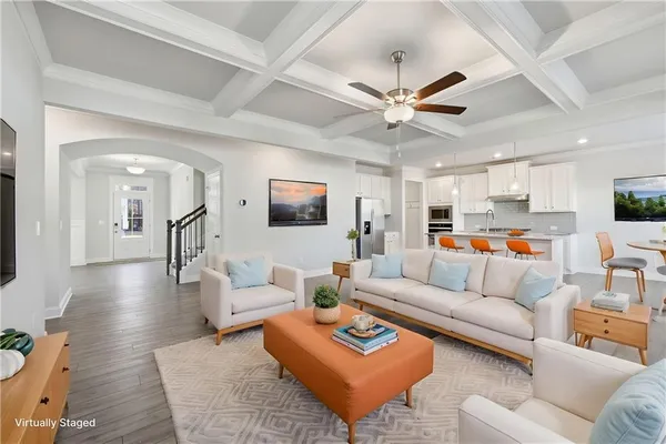 a living room with furniture kitchen view and a chandelier