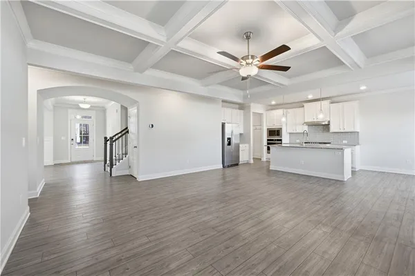 a view of a big room with wooden floor and a kitchen