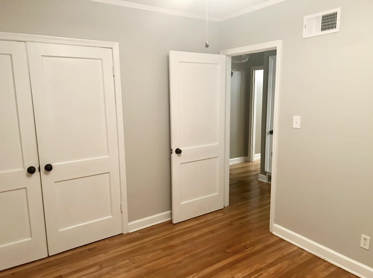505 High Point Terrace Memphis, TN 38122 - Photo 12 of 29 Unfurnished bedroom featuring crown molding, a closet, wood finished floors, baseboards, and visible vents