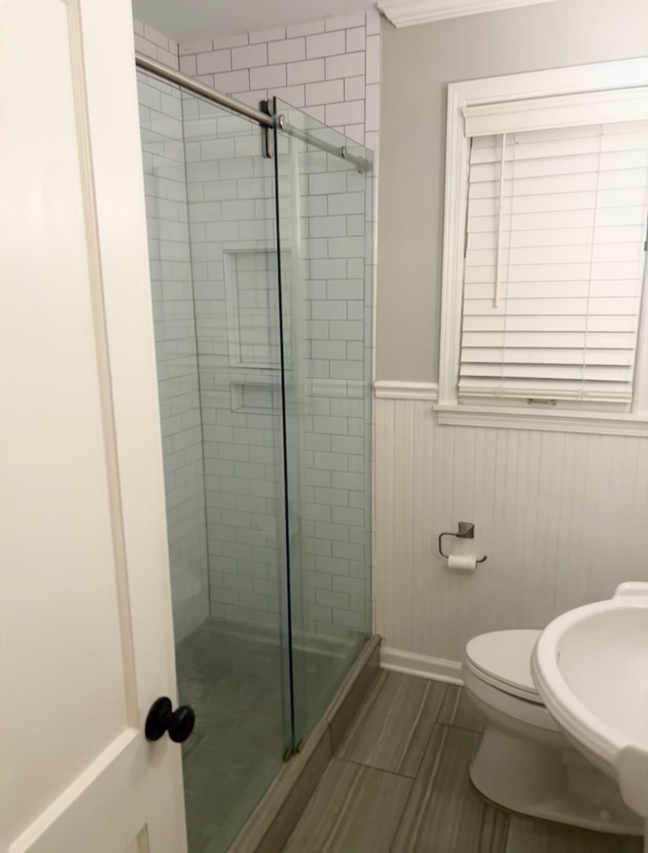 505 High Point Terrace Memphis, TN 38122 - Photo 15 of 29 Full bathroom featuring a wainscoted wall, a sink, toilet, and a shower stall