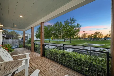 a view of a balcony with chairs and wooden floor