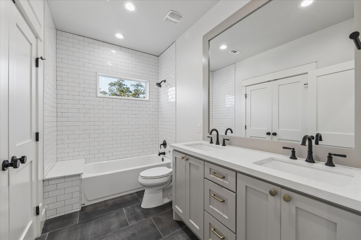910 Northwood Street Houston, TX 77009 - Photo 32 of 41 a bathroom with a double vanity sink a toilet and a bathtub