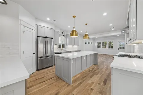 a kitchen with kitchen island granite countertop a sink cabinets and stainless steel appliances