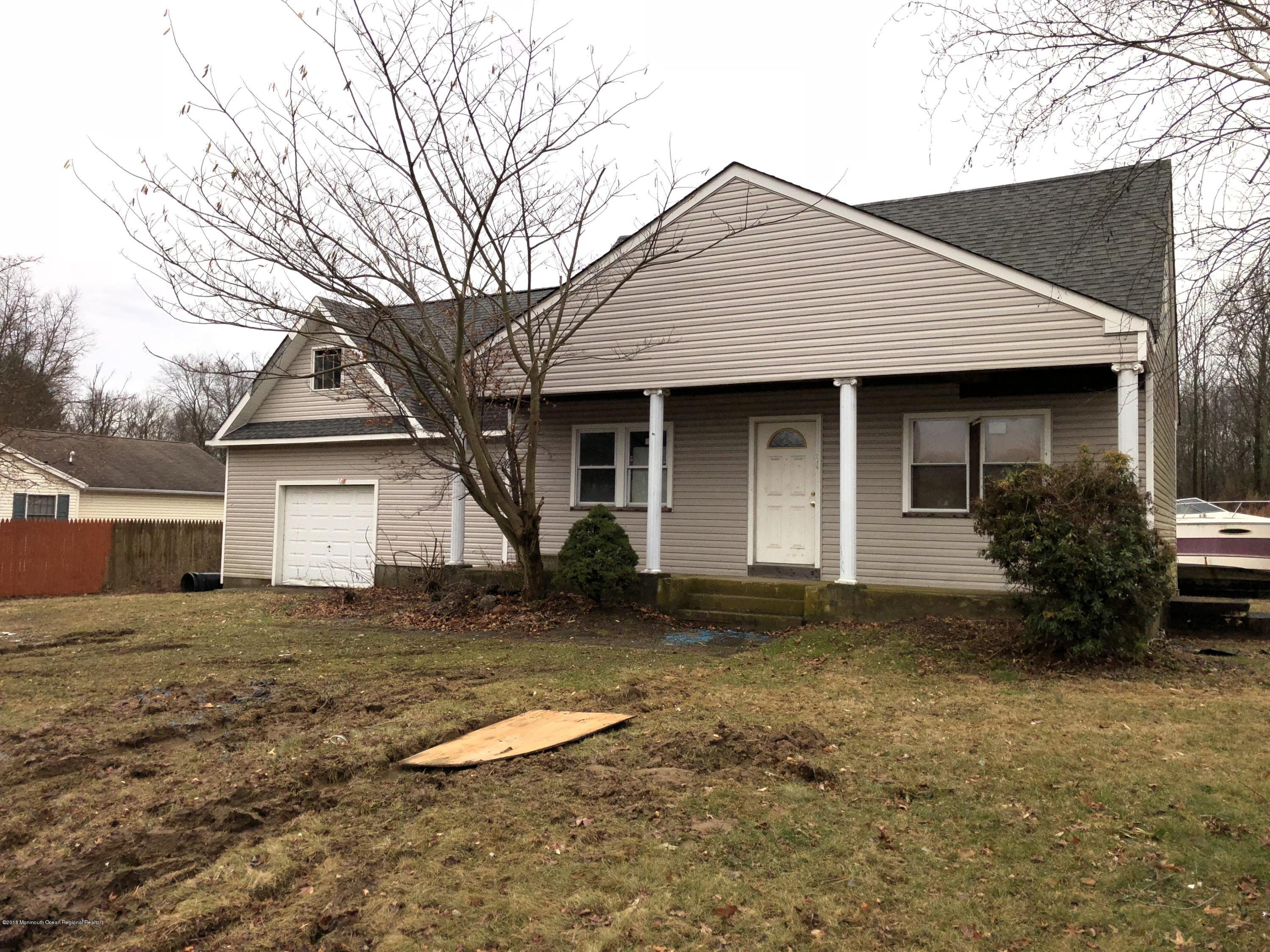 a front view of house with yard and trees in the background