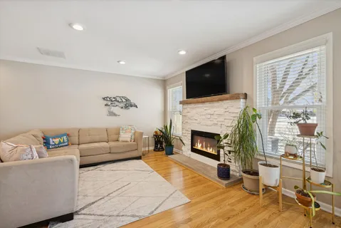 a living room with furniture a flat screen tv and a fireplace