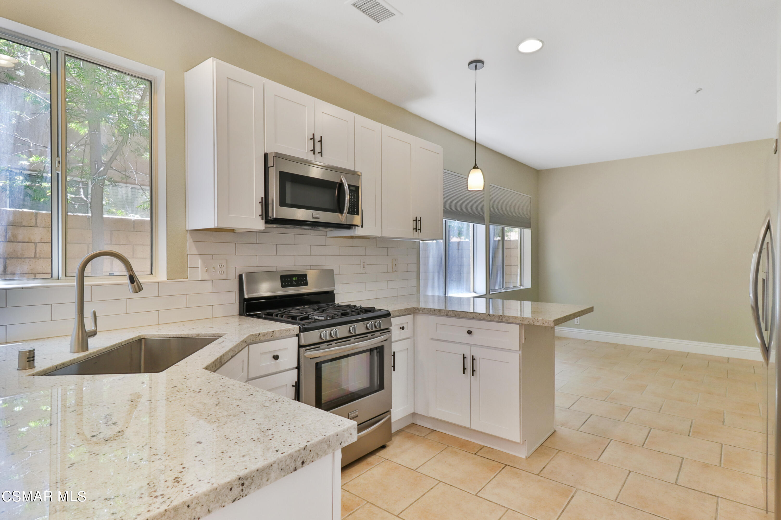 292 Maywind Lane Simi Valley, CA 93065 - Photo 5 of 41 a kitchen with granite countertop a stove a sink and a microwave